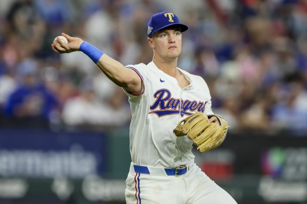 Texas Rangers third baseman Josh Jung throws to first between innings during a baseball game against the Chicago Cubs, Sunday, March 31, 2024, in Arlington, Texas. (AP Photo/Gareth Patterson)