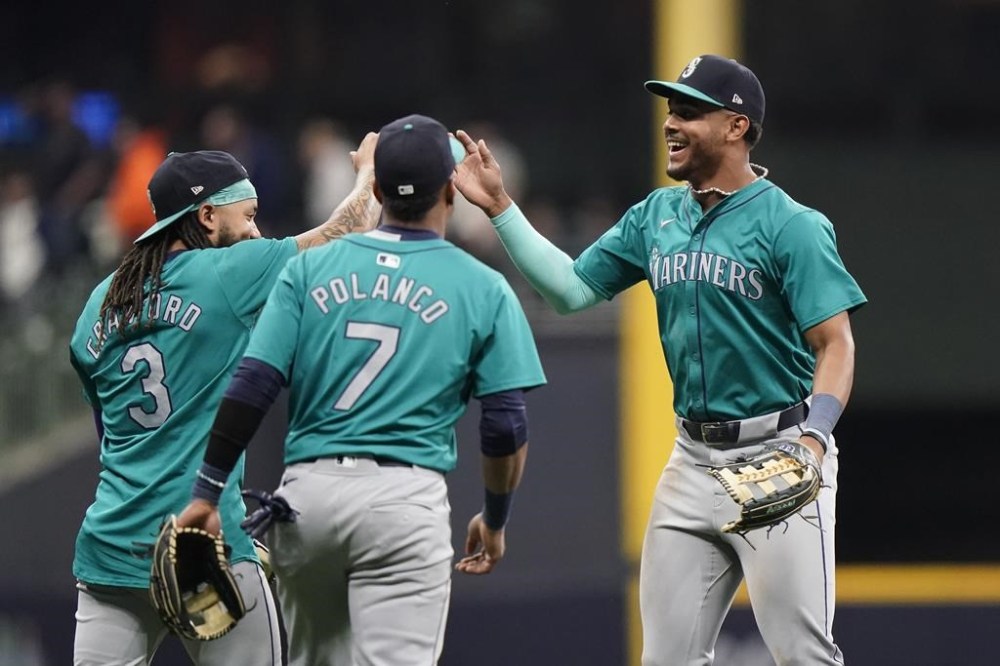 Seattle Mariners' Julio Rodríguez, right, celebrates with J.P. Crawford (3) and Jorge Polanco (7) after a baseball game against the Milwaukee Brewers Saturday, April 6, 2024, in Milwaukee. (AP Photo/Aaron Gash)