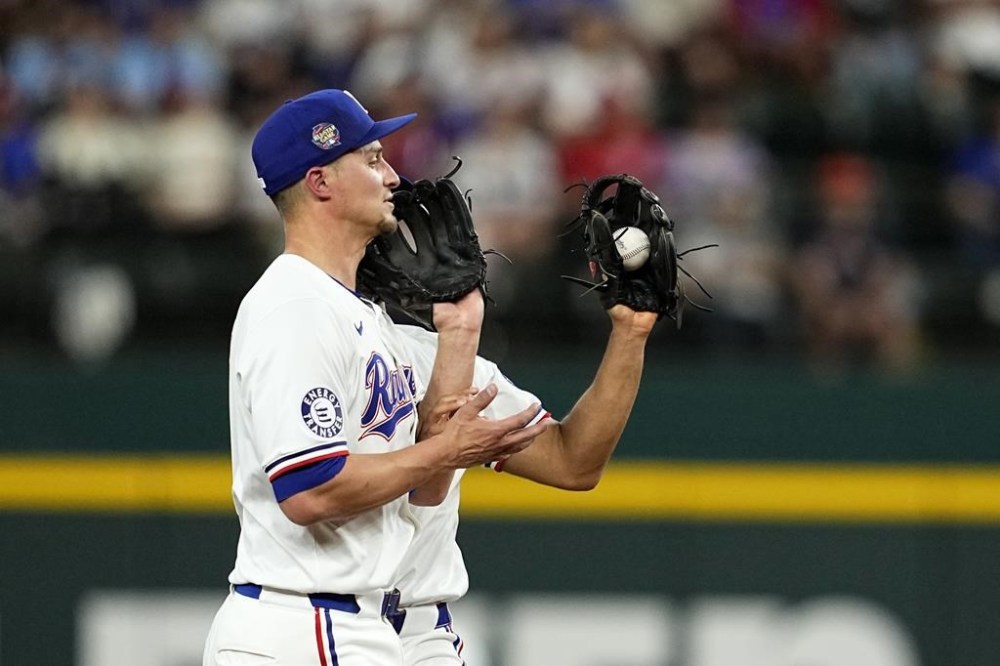 Texas Rangers shortstop Corey Seager, front, and second baseman Marcus Semien, rear, bump into each other as Semien catches a popup by Houston Astros' Jeremy Peña during the fourth inning of a baseball game in Arlington, Texas, Saturday, April 6, 2024. (AP Photo/Tony Gutierrez)