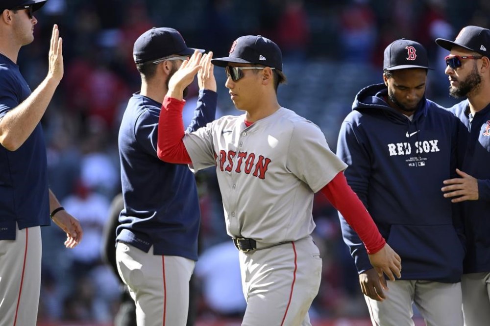Boston Red Sox's Masataka Yoshida, center right, greets teammates after a baseball game against the Los Angeles Angels in Anaheim, Calif., Sunday, April 7, 2024. (AP Photo/Alex Gallardo)