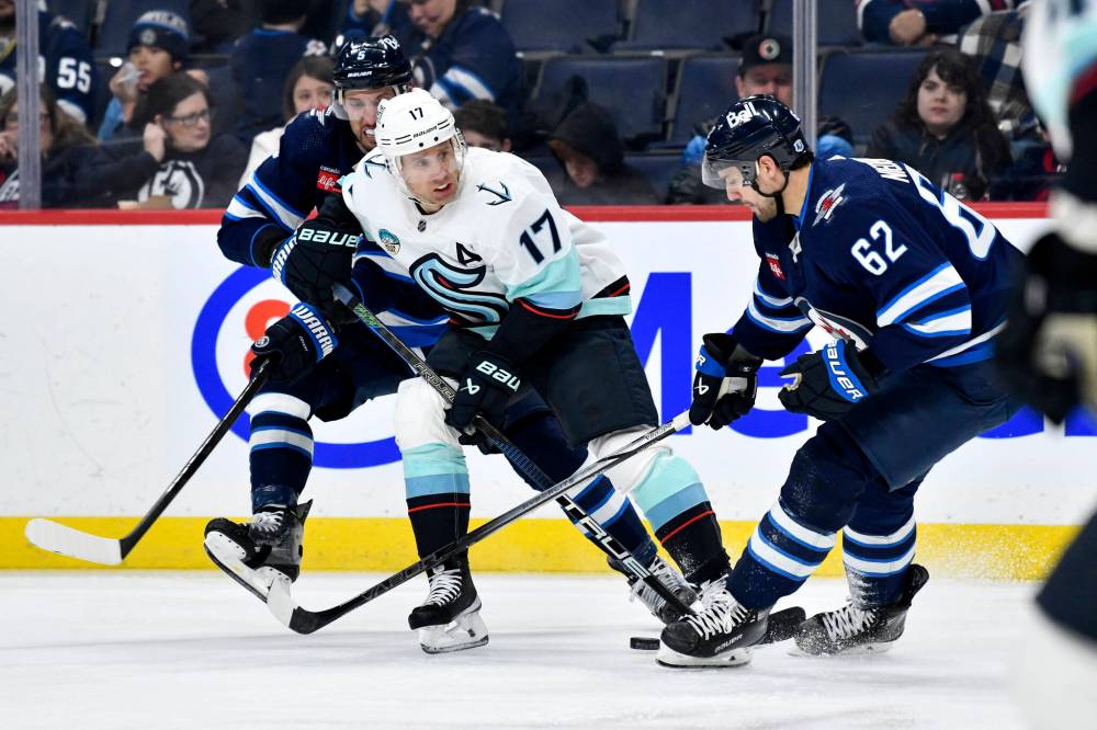 Fred Greenslade / THE CANADIAN PRESS
Seattle Kraken’s Jaden Schwartz is checked by Winnipeg Jets’ Brenden Dillon and Nino Niederreiter during the second period.