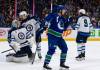 Winnipeg Jets goaltender Connor Hellebuyck (37) sits dejected as Neal Pionk (4) talks to him after Vancouver Canucks’ Pius Suter (24) scores during the third period of an NHL game, in Vancouver, Saturday, March 9, 2024. THE CANADIAN PRESS/Ethan Cairns