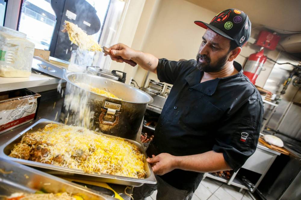 JOHN WOODS / FREE PRESS
Jehangir Khan, owner of the Barbecue Hut, prepares Chicken Biryani for an iftar buffet.