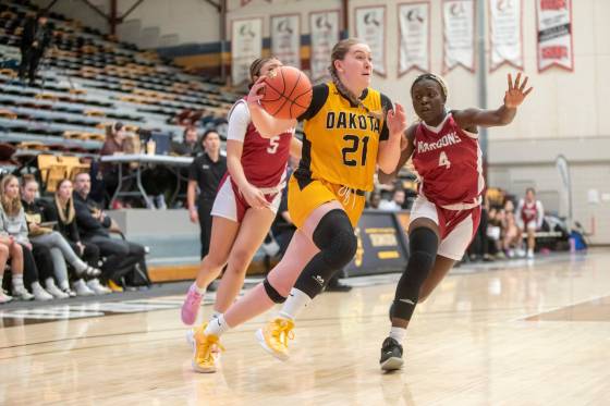 Lancers forward Darya Rom drives to the hoop while Maroons forward Grace Lou (right) guards her Wednesday night. (Brook Jones / Free Press files)