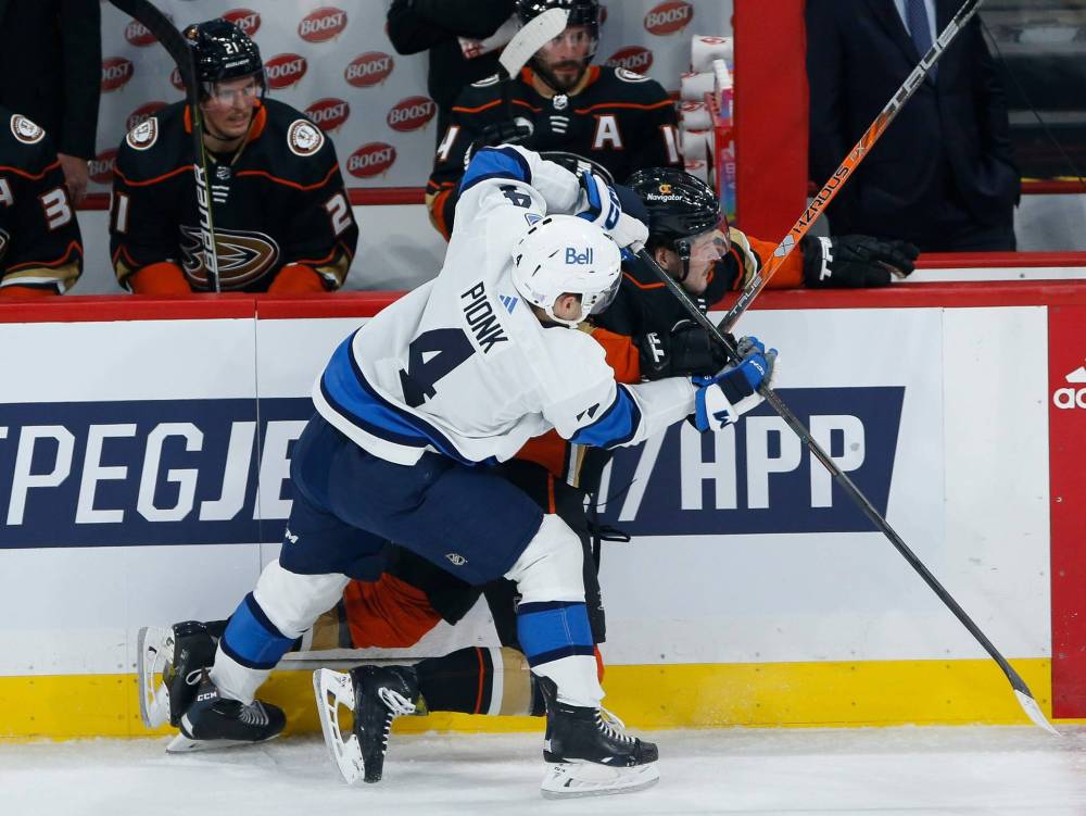 John Woods /THE CANADIAN PRESS files
Jets D-man Neal Pionk introduces Anaheim’s Mason McTavish to the boards.