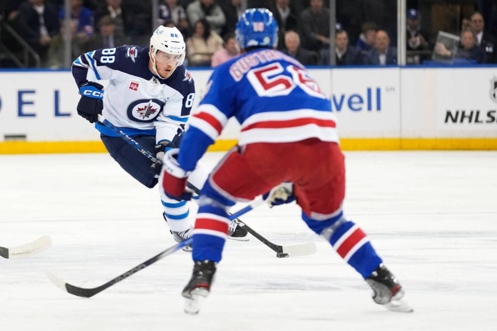 Mary Altaffer / The Associated Press
Winnipeg Jets defenceman Nate Schmidt carries the puck towards New York Rangers defenceman Ryan Lindgren during the first period.