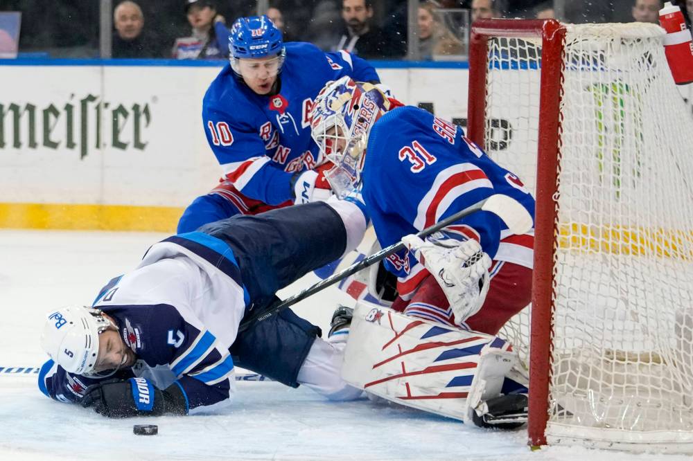 Mary Altaffer / The Associated Press
Jets defenceman Brenden Dillon crashes into New York Rangers goaltender Igor Shesterkin on Tuesday during the first-period.