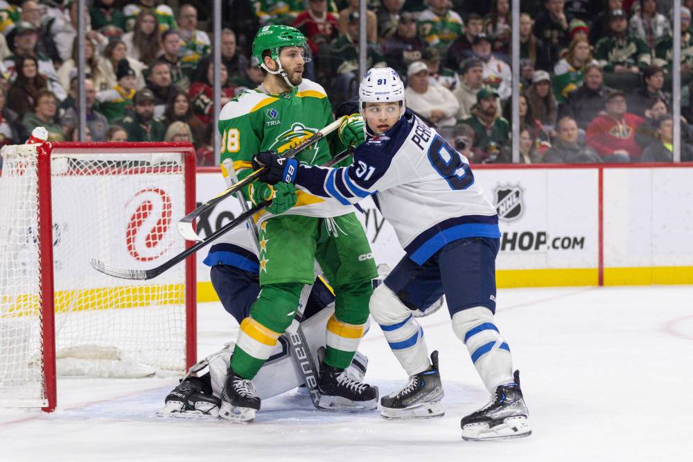 BAILEY HILLESHEIM / THE ASSOCIATED PRESS FILES
Jets forward Cole Perfetti (right) mixes it up with Minnesota’s Ryan Hartman in front of the Winnipeg net.
