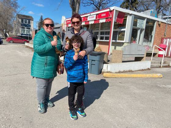 Jen Broesky (from left), Miranda Hood and Declan Hood enjoy their first BDI treat of the season. (Malak Abas / Free Press)