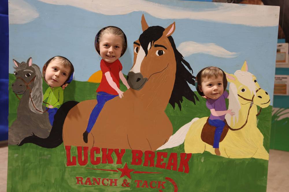 Three children have fun putting their faces in a cut out board while in the children’s area in the Flynn Arena at the Royal Manitoba Winter Fair on Monday. (Michele McDougall / The Brandon Sun)