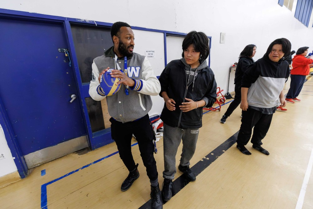 MIKE DEAL / FREE PRESS
Brandon Alexander (left) shows 8th grader, Lyle Loonfoot, how to throw a spiral.