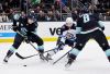 Winnipeg Jets defenseman Dylan DeMelo (2) shoots between Seattle Kraken left wing Jared McCann (19) and defenseman Brian Dumoulin (8) with the shot blocked during the second period of an NHL hockey game, Friday, March 8, 2024, in Seattle. (AP Photo/John Froschauer)