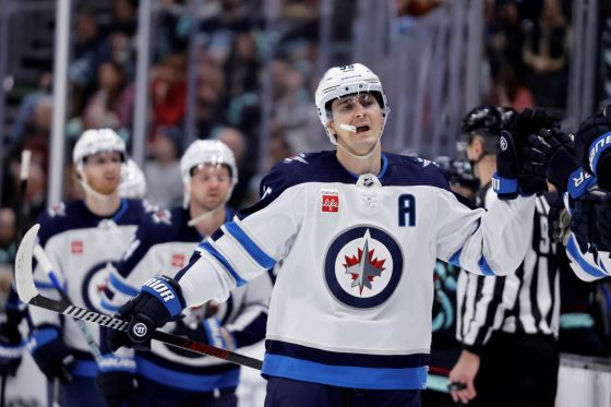 Winnipeg Jets center Mark Scheifele (55) is congratulated after scoring against the Seattle Kraken during the third period of an NHL hockey game, Friday, March 8, 2024, in Seattle. (AP Photo/John Froschauer)
