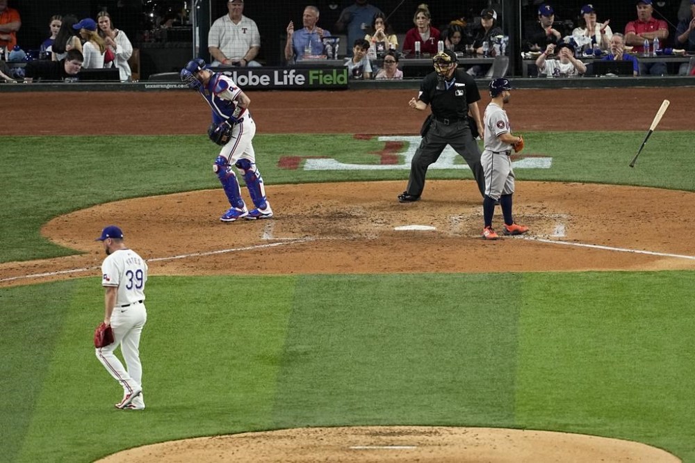Houston Astros' Jose Altuve, right, tosses his bat after striking out against Texas Rangers' Kirby Yates (39) in the sixth inning of a baseball game in Arlington, Texas, Saturday, April 6, 2024. Rangers catcher Jonah Heim heads to the dugout as umpire Larry Vanover looks on. (AP Photo/Tony Gutierrez)