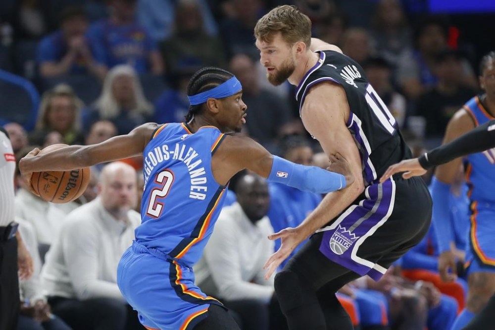 Oklahoma City Thunder guard Shai Gilgeous-Alexander (2) is defended by Sacramento Kings forward Domantas Sabonis during the first half of an NBA basketball game Tuesday, April 9, 2024, in Oklahoma City. (AP Photo/Nate Billings)