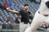 Arizona Diamondbacks starting pitcher Merrill Kelly throws to first base to put out Colorado Rockies' Nolan Jones in the second inning of a baseball game Tuesday, April 9, 2024, in Denver. (AP Photo/David Zalubowski)