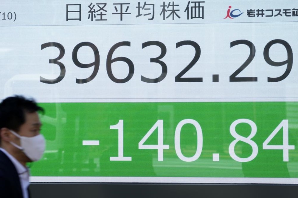 A man walks past an electronic stock board showing Japan's Nikkei 225 index at a securities firm Wednesday, April 10, 2024 in Tokyo. (AP Photo/Shuji Kajiyama)