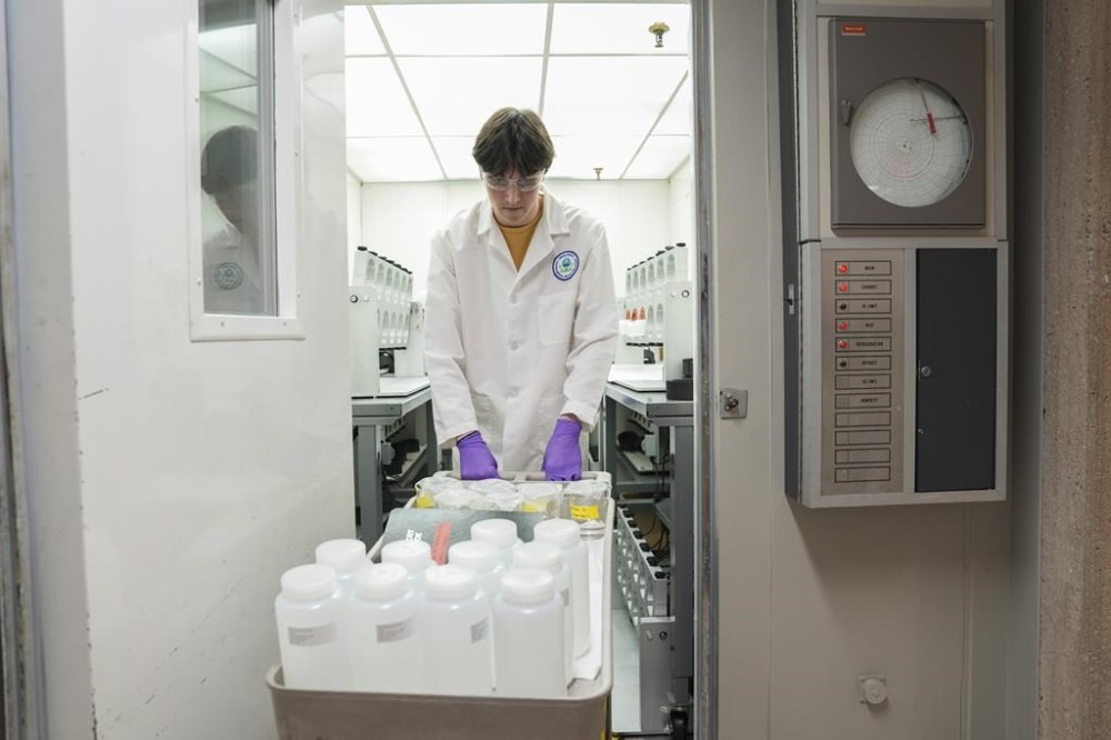 Jackson Quinn brings PFAS water samples into a temperature controlled room, Wednesday, April 10, 2024, at a U.S. Environmental Protection Agency lab in Cincinnati. The Environmental Protection Agency on Wednesday announced its first-ever limits for several common types of PFAS, the so-called