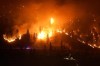 The McDougall Creek wildfire burns on the mountainside above a lakefront home, in West Kelowna, B.C., on August 18, 2023. As Canada looks ahead to what experts fear could be another devastating wildfire season, fire chiefs are worried about the dwindling number of volunteer firefighters available to combat the rising threat. THE CANADIAN PRESS/Darryl Dyck