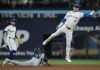 Seattle Mariners outfielder Dylan Moore (25) steals second base past Toronto Blue Jays' Cavan Biggio (8) during third inning American League MLB baseball action in Toronto on Wednesday, April 10, 2024. THE CANADIAN PRESS/Nathan Denette