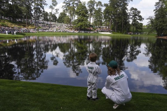 Peter Malnati's son Hatcher and wife Alicia, watch on the ninth hole during the par-3 contest at the Masters golf tournament at Augusta National Golf Club Wednesday. (Charlie Riedel / The Associated Press)