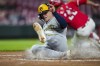 Milwaukee Brewers' Jake Bauers scores a run on a single by Jackson Chourio during the second inning of a baseball game against the Cincinnati Reds in Cincinnati, Wednesday, April 10, 2024. (AP Photo/Aaron Doster)