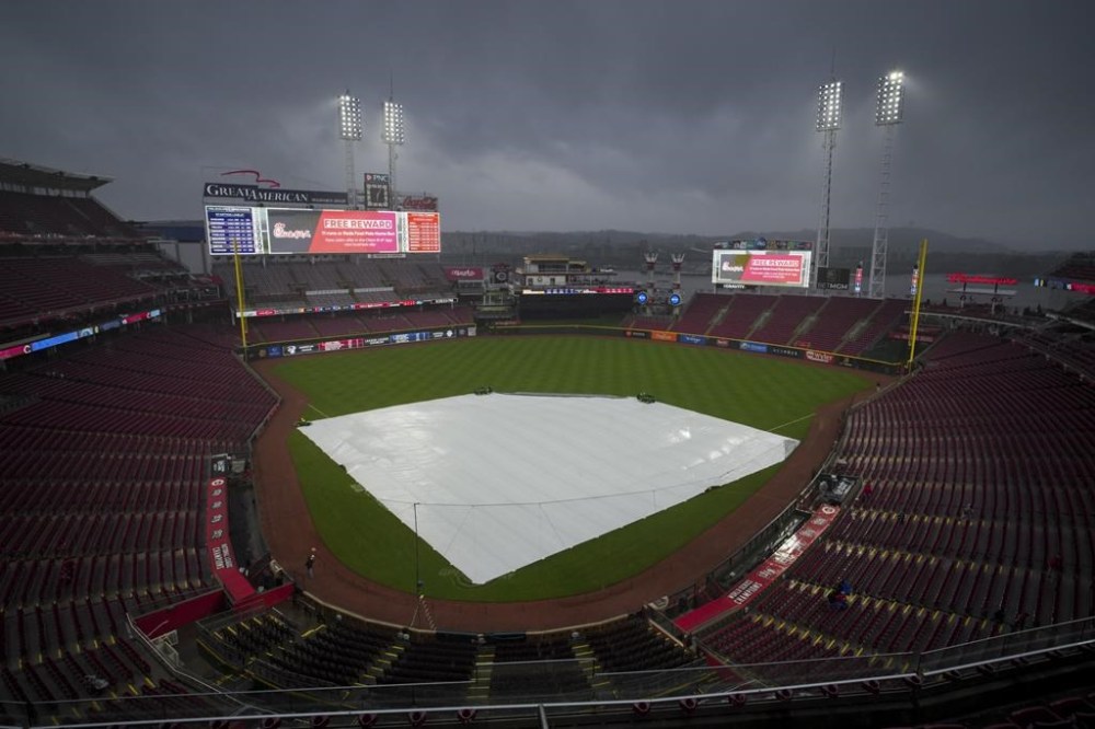 A view of the tarp on the field as rain falls before a baseball game against the Milwaukee Brewers and the Cincinnati Reds in Cincinnati, Wednesday, April 10, 2024. The game was delayed due to inclement weather. (AP Photo/Aaron Doster)