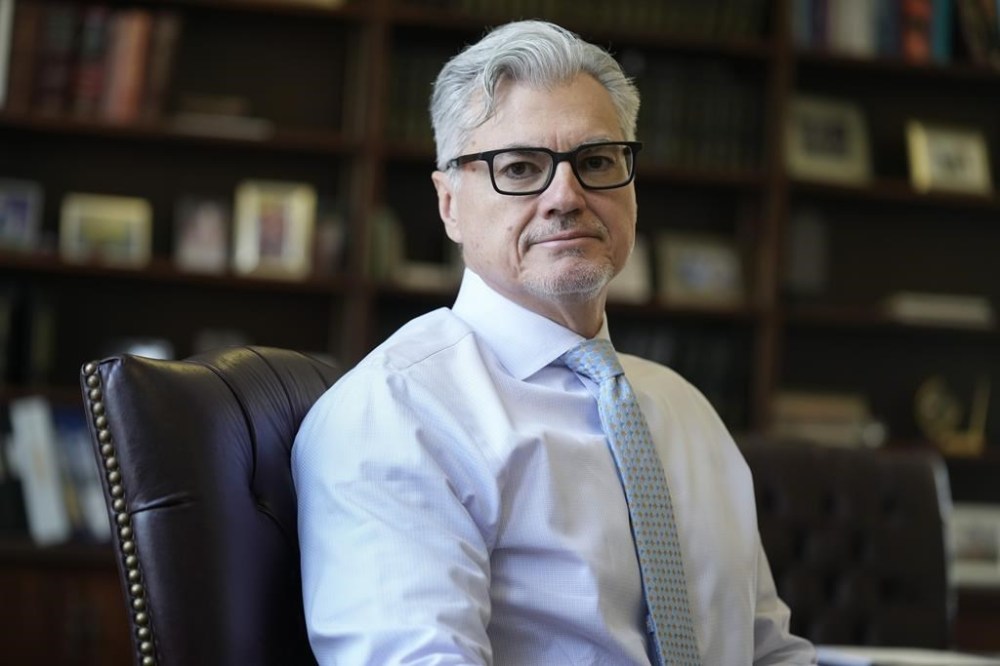 FILE - Judge Juan M. Merchan poses in his chambers in New York, Thursday, March 14, 2024. Citing Trump's threatening and inflammatory statements, Merchan imposed a gag order last month that bars Trump from publicly commenting on witnesses, jurors or others involved in the case — though not Bragg or the judge personally. (AP Photo/Seth Wenig, File)