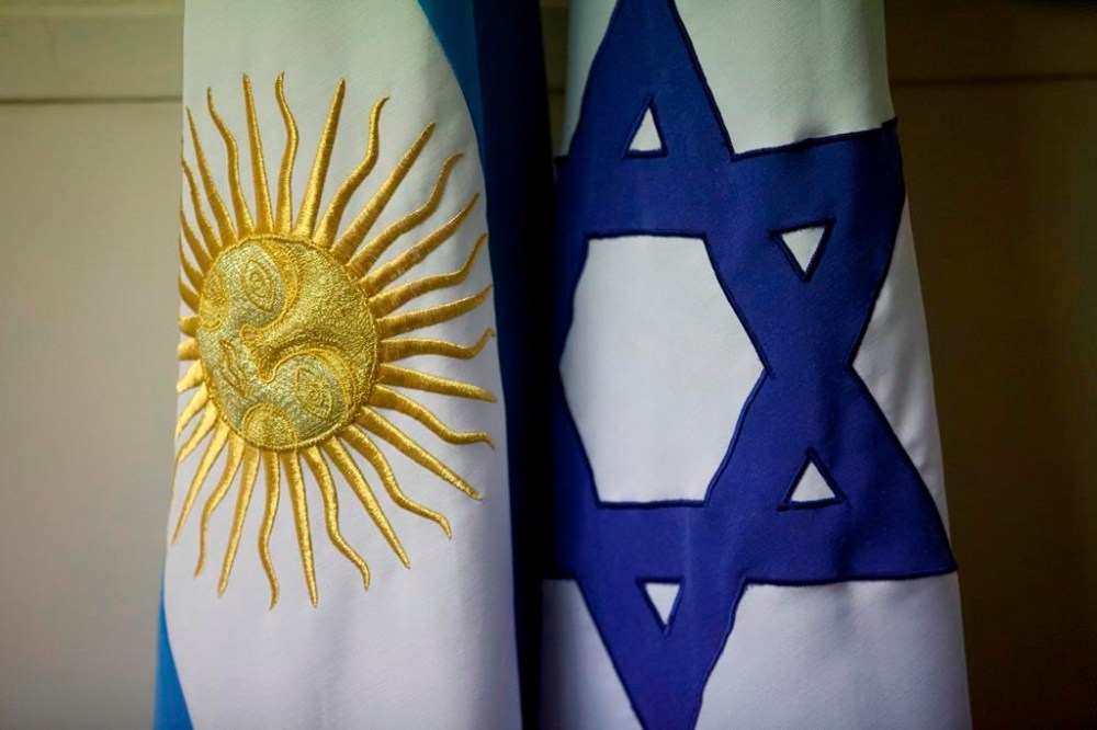 FILE - An Argentine and Israeli flag stand side by side at the office of Guillermo Borger, president of the Jewish community center AMIA, during an interview with The Associated Press in Buenos Aires, Argentina, on Feb. 8, 2013. Argentina’s highest criminal court on Thursday, April 12, 2024, reported a new development in the elusive quest for justice in the country’s deadliest attack in history – the 1994 bombing of a Jewish community center headquarters – concluding Iran had planned the attack and Lebanon’s Hezbollah militant group had executed the plans. (AP Photo/Victor R. Caivano)