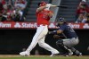 Los Angeles Angels' Mike Trout follows through on a two-run home run next to Tampa Bay Rays catcher Rene Pinto during the first inning of a baseball game in Anaheim, Calif., Tuesday, April 9, 2024. (AP Photo/Alex Gallardo)