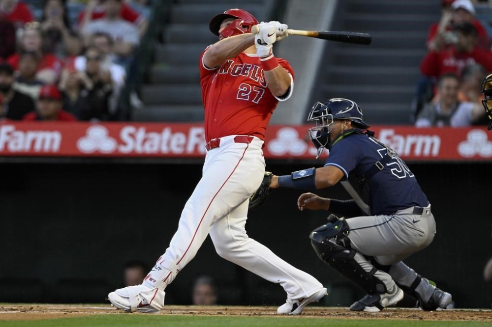 Los Angeles Angels' Mike Trout follows through on a two-run home run next to Tampa Bay Rays catcher Rene Pinto during the first inning of a baseball game in Anaheim, Calif., Tuesday, April 9, 2024. (AP Photo/Alex Gallardo)