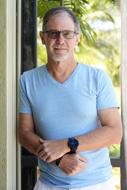Scott Berkheiser, who has Alzheimer's disease, stands for a portrait at his home Friday, April 5, 2024, in Venice, Fla. Insurance denials delayed Berkheiser’s first Leqembi infusion a few months until last December. He said the drugmaker eventually agreed to give it to him for free while he makes co-payments for the infusions. “It was a little crazy,” he said. “It seemed like it was kind of a game that must make sense for some monetary reason.” (AP Photo/Chris O'Meara)