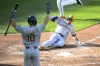 Milwaukee Brewers' Oliver Dunn (15) slides home to score on a single by William Contreras during the fourth inning of a baseball game against the Baltimore Orioles, Saturday, April 13, 2024, in Baltimore. Brewers' Sal Frelick (10) is at front. (AP Photo/Nick Wass)