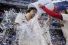 Philadelphia Phillies' Nick Castellanos, left, is doused by teammates Bryson Stott, right, Brandon Marsh, center, after hitting a walkoff single in the ninth inning of a baseball game against the Pittsburgh Pirates, Saturday, April 13, 2024, in Philadelphia. (AP Photo/Laurence Kesterson)