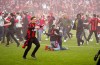 Leverkusen fans celebrate on the pitch after Bayer Leverkusen won the German Bundesliga title beating Werder Bremen in Leverkusen, Germany, Sunday, April 14, 2024. (AP Photo/Martin Meissner)