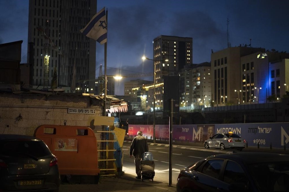 An elderly Jewish man pulls his cart on a street during the dusk in Jerusalem, Sunday, April 14, 2024. Israel on Sunday hailed its air defenses in the face of an unprecedented attack by Iran, saying the systems thwarted 99% of the more than 300 drones and missiles launched toward its territory. THE CANADIAN PRESS/AP-Leo Correa