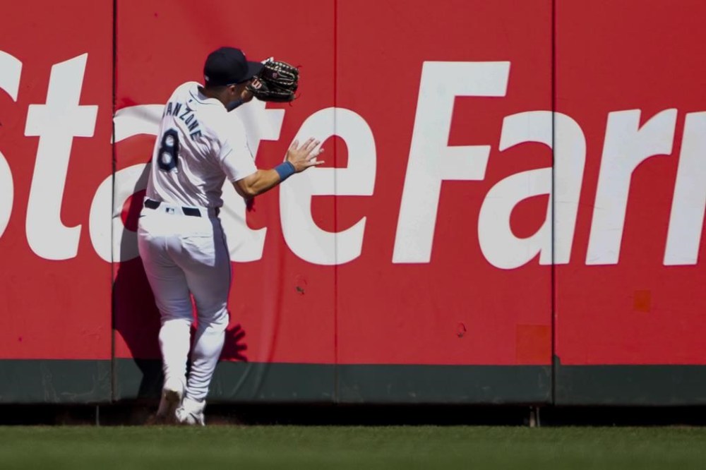 Seattle Mariners left fielder Dominic Canzone collides with the wall after catching a fly ball hit by Chicago Cubs' Mike Tauchman during the second inning of a baseball game Sunday, April 14, 2024, in Seattle. Canzone would leave the game due to injury after the play. (AP Photo/Lindsey Wasson)