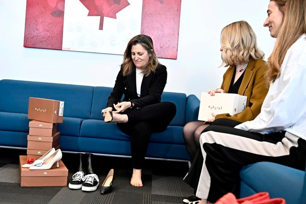 Deputy Prime Minister and Minister of Finance Chrystia Freeland tries on a pair of shoes from direct-to-consumer footwear company Maguire during a pre-budget photo op in her office in Ottawa, Monday, April 15, 2024. THE CANADIAN PRESS/Justin Tang