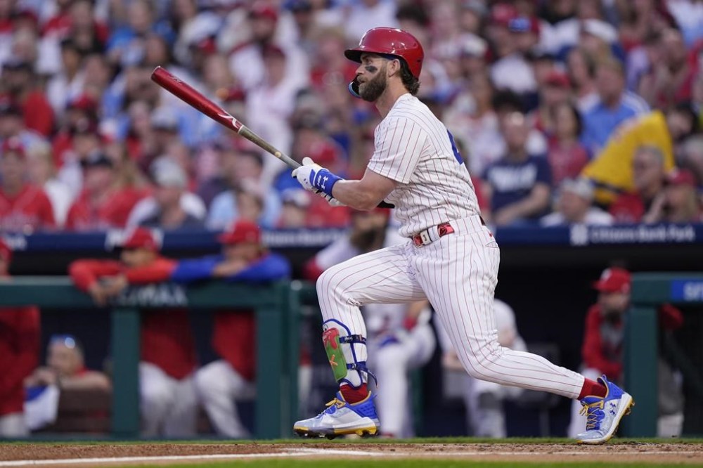 Philadelphia Phillies's Bryce Harper follows through after hitting an RBI single off Colorado Rockies' Cal Quantrill during the third inning of a baseball game, Monday, April 15, 2024, in Philadelphia. (AP Photo/Matt Rourke)