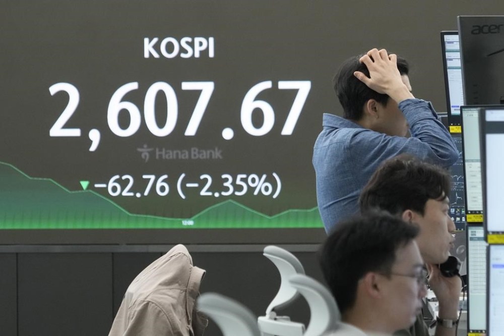 Currency traders work near the screen showing the Korea Composite Stock Price Index (KOSPI) at the foreign exchange dealing room of the KEB Hana Bank headquarters in Seoul, South Korea, Tuesday, April 16, 2024. (AP Photo/Ahn Young-joon)