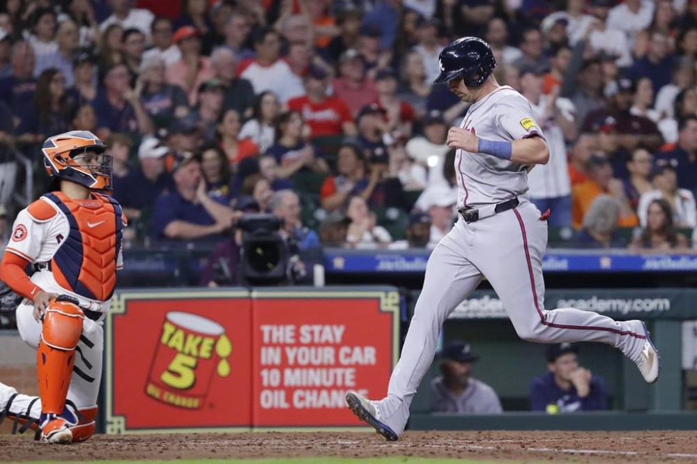 Atlanta Braves third baseman Austin Riley, right, scores in front of Houston Astros catcher Yainer Diaz, left, on the sacrifice fly by Orlando Arcia during the seventh inning of a baseball game Tuesday, April 16, 2024, in Houston. (AP Photo/Michael Wyke)