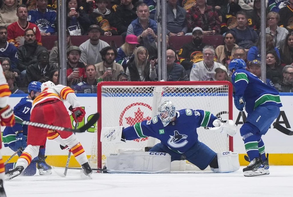 Vancouver Canucks goalie Thatcher Demko (35) stops Calgary Flames' Martin Pospisil, front left, during the second period of an NHL hockey game in Vancouver, on Tuesday, April 16, 2024. THE CANADIAN PRESS/Darryl Dyck