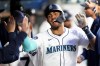 Seattle Mariners' Julio Rodríguez celebrates in the dugout after scoring on a bases-loaded walk during the fifth inning of the team's baseball game against the Cincinnati Reds on Tuesday, April 16, 2024, in Seattle. (AP Photo/Lindsey Wasson)