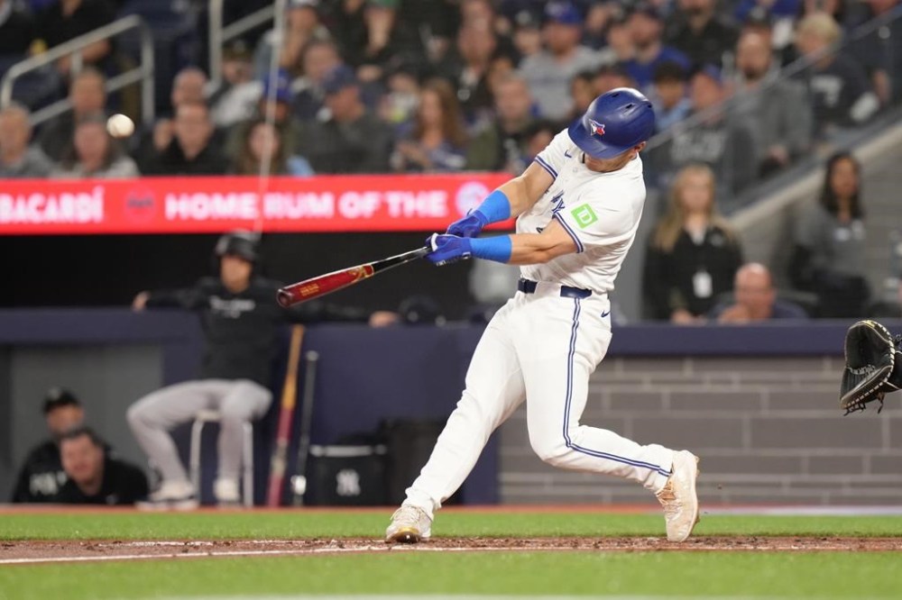 Toronto Blue Jays outfielder Daulton Varsho (25) hits a two-run homer driving in Davis Schneider during second inning American League MLB baseball action against New York Yankees pitcher Marcus Stroman in Toronto on Wednesday, April 17, 2024. THE CANADIAN PRESS/Chris Young