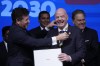 Conmebol President Alejandro Dominguez, left, honors FIFA President Giovanni Infantino with the honor collar during the 78th Conmebol Congress in Luque, Paraguay, Thursday, April 11, 2024. (AP Photo/Jorge Saenz)
