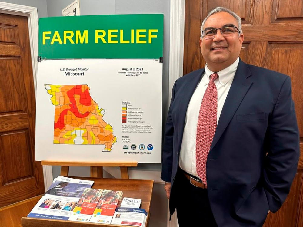 FILE - Missouri Treasurer Vivek Malek stands near a poster promoting drought conditions and state aid programs, Jan. 4, 2024, at his Capitol office in Jefferson City, Mo. Agricultural entities are among several categories of businesses that can receive low-interest loans backed by deposits of state funds made by the treasurer's office. Missouri lawmakers gave final approval Thursday, April 18, to significantly expand a low-interest loan program for farmers and small businesses. (AP Photo/David A. Lieb, File)