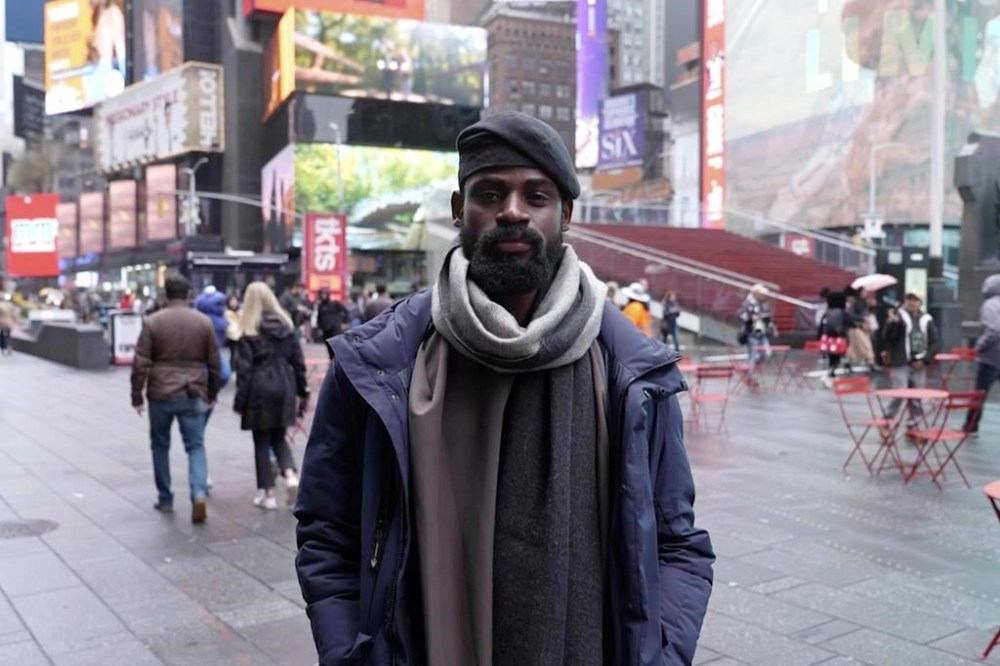 In this screen grab taken from video, Tunde Onakoya, 29- years old, a Nigerian chess champion and child education advocate, poses on the street in Times Square, New York, Thursday, April, 18, 2024. A Nigerian chess player and child education advocate is attempting to play chess nonstop for 58 hours in New York City's Times Square to break the global record for the longest chess marathon and raise $1m for the education of children across Africa. (AP Video/John Minchillo)