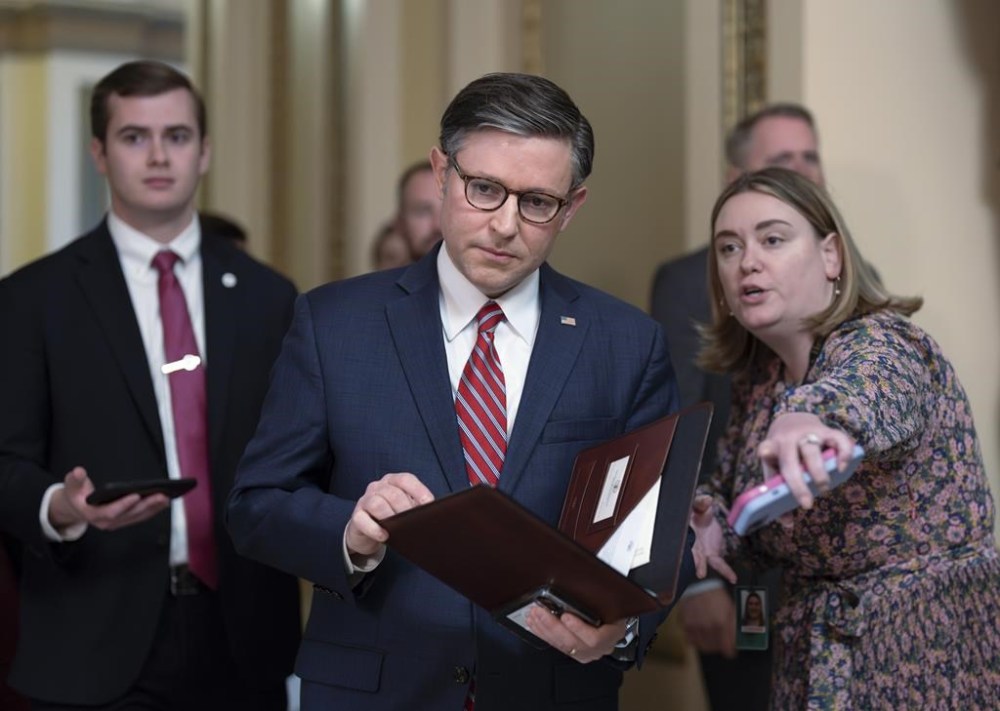 Speaker of the House Mike Johnson, R-La., , center, stops to talk to reporters just after lawmakers pushed a $95 billion national security aid package for Ukraine, Israel and other U.S. allies closer to passage, at the Capitol in Washington, Friday, April 19, 2024. (AP Photo/J. Scott Applewhite)