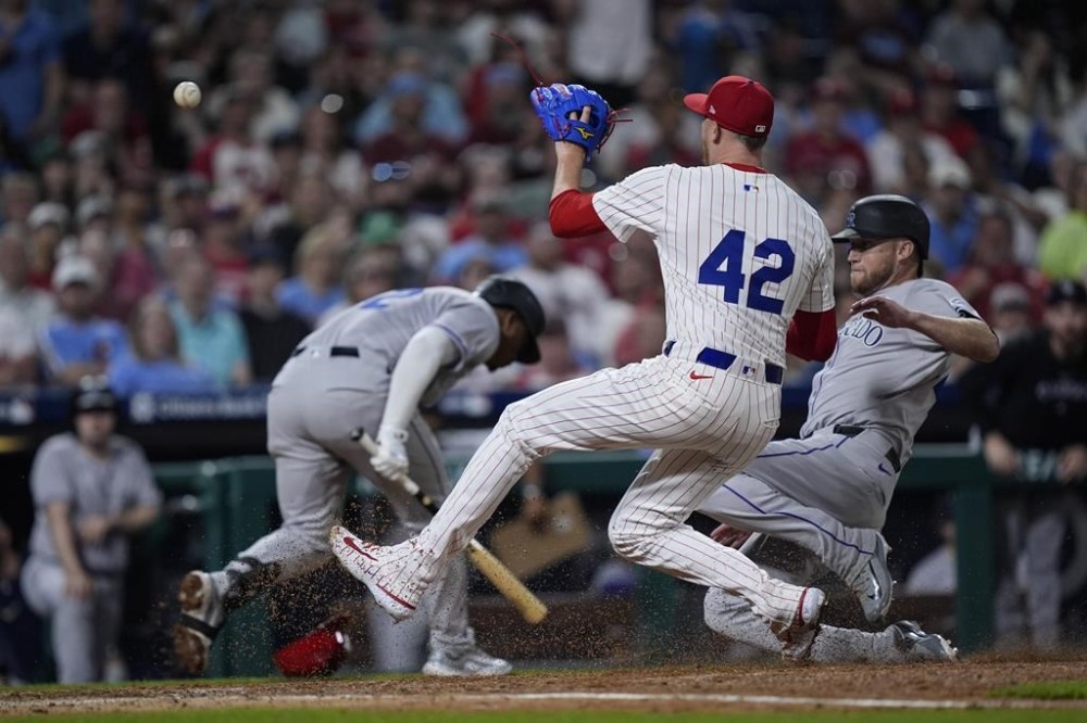 Philadelphia Phillies pitcher Jeff Hoffman, center, awaits the ball to tag out Colorado Rockies' Kyle Freeland, right, at home plate during the ninth inning of a baseball game, Monday, April 15, 2024, in Philadelphia. (AP Photo/Matt Rourke)