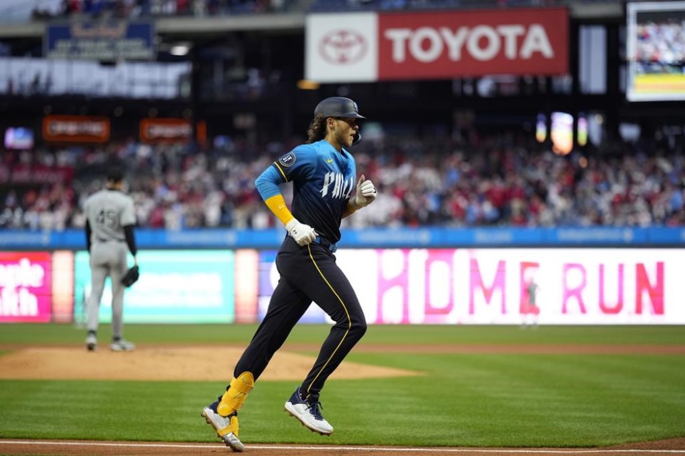 Philadelphia Phillies' Alec Bohm, right, rounds the bases after hitting a three-run home run against Chicago White Sox pitcher Garrett Crochet during the first inning of a baseball game, Friday, April 19, 2024, in Philadelphia. (AP Photo/Matt Slocum)